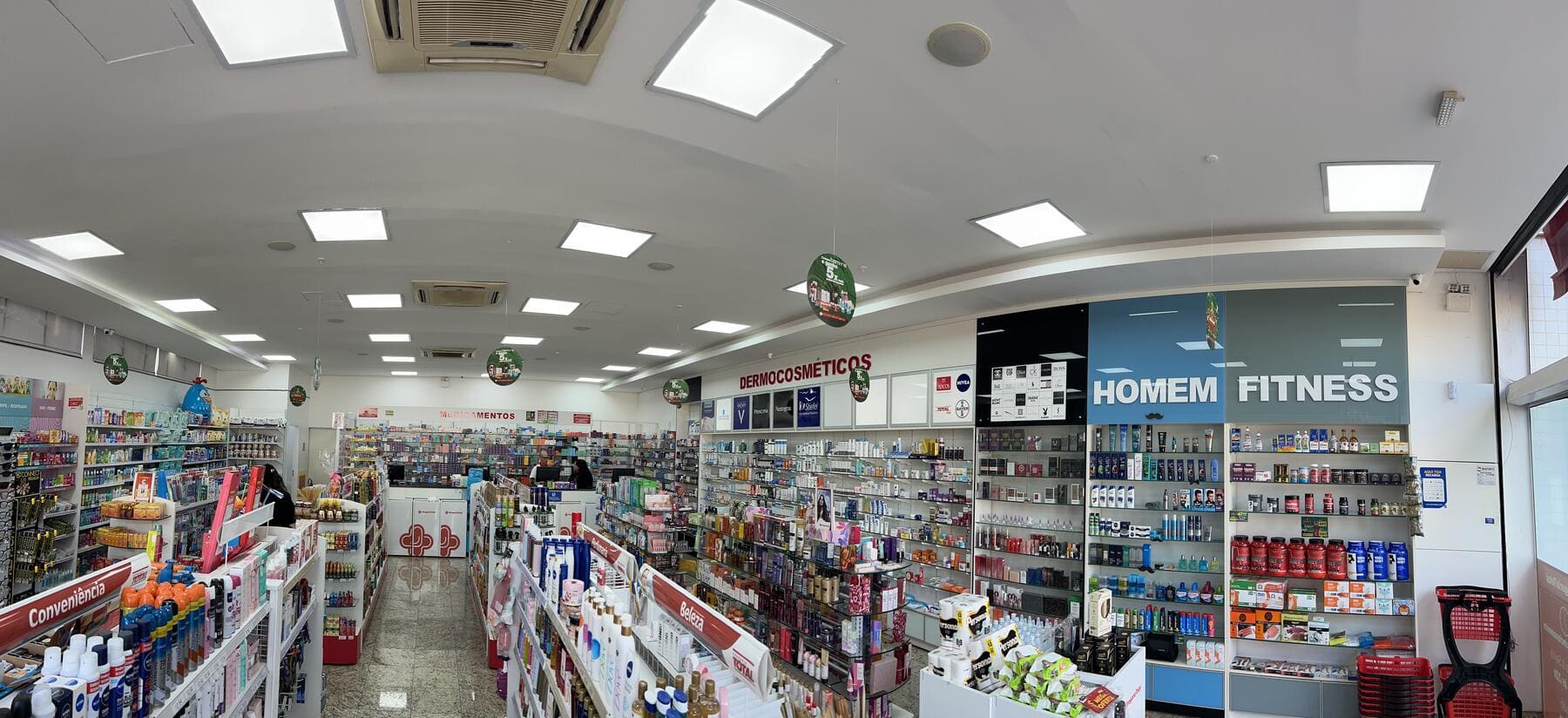 Interior da Drogaria Total Irajá — corredor com produtos
